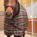 Close-up of the Shires Tempest Plus Lite stable rug in green tartan, highlighting adjustable chest straps and SupaFleece fleece-lined neckline.