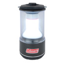 A Coleman lantern with a transparent body and black base, illuminating a bright white light, ideal for outdoor activities.