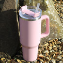 A pink water bottle with a clear lid and straw, as well as a handle on the side.