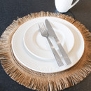 A small white side plate stacked on top of a dinner plate, with a knife and fork placed on top.