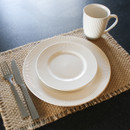A small white side plate stacked on top of a dinner plate.