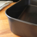 A close up view of the corner of the metal roasting pan.