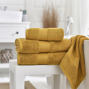 A bale of yellow towels with one draped over the bath