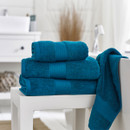 A bale of blue towels with a towel draped over the bath