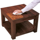 A person wipes a wooden coffee table with a cloth, removing circular water stains from its surface.