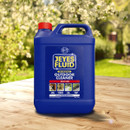 A blue bottle of Jeyes Fluid Outdoor Cleaner sits on a wooden table with a sunny garden background, labelled "kills 99.9% bacteria."