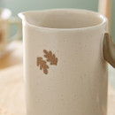 A close up view of a large ceramic Cooksmart Forest Fable serving jug with a leaping hare design on a wooden table