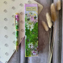 A vibrant Alex Clark ballpoint pen adorned with floral artwork, next to its decorative box on a textured surface.