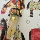 A decorated pen rests on whimsical horse-themed stationery, showcasing vibrant illustrations and the name "Alex Clark."