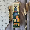 A decorative pen beside a playful animal-themed box, on a wood surface with floral accents and horse-print paper below.
