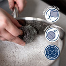 A person cleaning a pan with a scourer.
