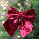 A close up view of a red velvet bow decoration on a Christmas tree