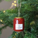 A view of a ceramic jar of cranberry sauce hanging decoration hanging on a Christmas tree