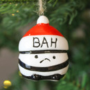 A close up view of a ceramic bah humbug hanging decorations hanging on a Christmas tree