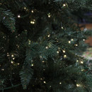 Close-up of an artificial Christmas tree branch adorned with twinkling lights.