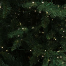 Close-up of an artificial Christmas tree branch adorned with twinkling lights.