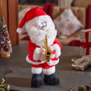 A plush Santa Claus in a red suit playing a golden saxophone, set against a cosy holiday backdrop with decorations.