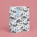 Winter ski scene Christmas gift bag with silver rope handles, featuring snowy chalets, pine trees, skiers and ski lifts with a blue "Merry Christmas" gift tag.