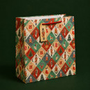 Christmas gift bag with red rope handles and matching nutcracker gift tag, featuring a colourful patchwork design with nutcrackers, Christmas trees, presents, stockings and rocking horses.