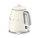 A cream mini SMEG kettle with silver base, spout and handle.