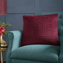 A view of a wine coloured cushion on a blue chair