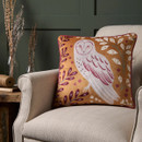 A view of a reversible gold cushion with an owl on a cream chair