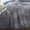 A view of a blue and cream checked throw over a bed