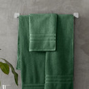 A view of a green Catherine Lansfield Zero Twist Cotton Hand Towel on a rail