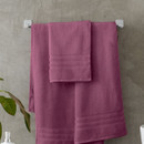 A view of a pink Catherine Lansfield Zero Twist Cotton Hand Towel on a rail