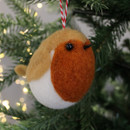 A plush robin ornament with brown and white wool and black bead eyes hangs on a tree. Soft focus lights create a cosy, festive atmosphere.