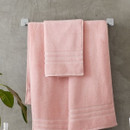 A view of a pink Catherine Lansfield Zero Twist Cotton Hand Towel on a rail