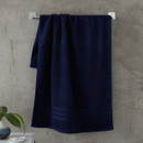 A view of a navy Catherine Lansfield Zero Twist Cotton Bath Towel on a on a rail