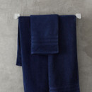 A view of a navy Catherine Lansfield Zero Twist Cotton Hand Towel on a rail