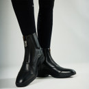 Close-up of elegant black equestrian boots with side zips, paired with smooth black riding socks featuring LeMieux branding.