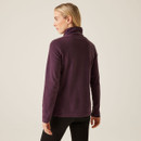 The back of a woman wearing a deep plum coloured fleece.