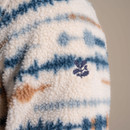 Embroidered leaf logo on sleeve of beige sherpa fleece with blue and brown stripes. Embroidered leaf logo on sleeve of beige sherpa fleece with blue and brown stripes.