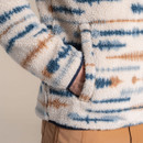 Close-up of beige sherpa fleece pocket with blue and brown striped detail. Close-up of beige sherpa fleece pocket with blue and brown striped detail.