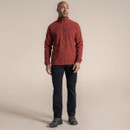 Man wearing black outdoor trousers with rust fleece jacket and hiking shoes.