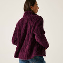 The back of a woman wearing a fig purple fluffy jacket with a cable knit effect.