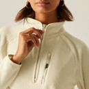 Close-up of the cream fleece showing the quarter zip, high collar and chest zip pocket detail.
