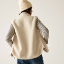 The back of a woman wearing a light coloured borg gilet.