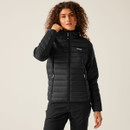A woman wearing a black quilted jacket with a hood.