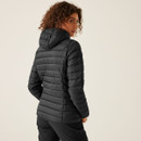 The back of a woman wearing a black quilted jacket with a hood.