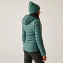 The back of a woman wearing a green quilted jacket with a hood.