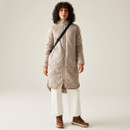 A full length view of a woman wearing a taupe, quilted jacket.