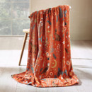 A view of a burnt orange Catherine Lansfield Enchanted Twghlight blanket on a chair