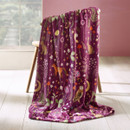 A view of a plum Catherine Lansfield Enchanted Twilight blanket throw on a chair