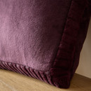 A close up view of a purple Catherine Lansfield velvet cushion