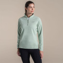 Woman wearing a mint green Craghoppers fleece pullover with half zip and high collar.