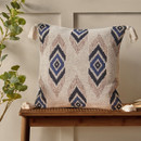 A view of a navy Emir Ikat Pineapple Elephant cushion on a wooden bench